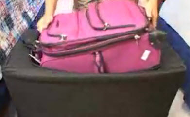 Pink suitcase entering a PackTite heat chamber